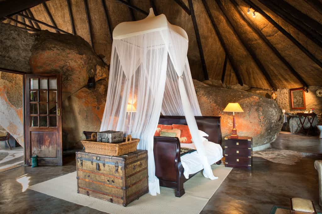  The Cecil John Rhodes Suite is the most secluded lodge, elevated to the back of the main area and behind Suite 8. There are 36 steps up to the room so would be most suitable for those guests that don’t mind a little uneven terrain.  The suite consists of an ensuite bathroom with toilet, his & hers showers, outside bath, rock basin, tea & coffee stations, a lounge area, fan, mosquito net, mosquito coils, open wardrobe, king-size bed, hairdryers & electric blankets. This suite boasts a swing bridge leading out to a private viewing sala overlooking the waterhole.