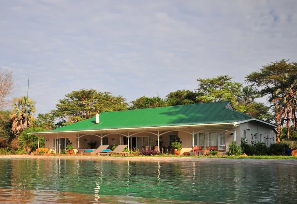 The shady verandah with outdoor seating and dining area overlooks the pool and the Zambezi