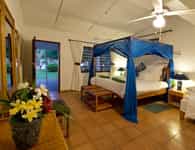 Canopy mosquito nets over beds. Rooms decorated in cool blues to a nautical theme.