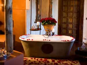 With a centrepiece of red roses has twin hand basins, shower, chandelierlit bathtub and seperate wc