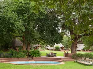 The swimming pool and al fresco eating area nestle under classic riverine trees