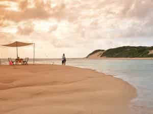 Couple on a romantic picnic on Inhaca Island are looking at the lodge.