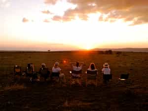 Guests watching the sun set from camp