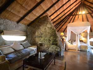 Room 3 is a Standard Family room on the ground level of Camp Amalinda and still incorporates some of the granite structures.  There are no stairs to Room 3 and it is an open plan bedroom, lounge & bathroom area with 2 double beds. The ensuite bathroom consists of a shower & bath, toilet and single rock basin. If required, there is space for an extra single bed in the family room.  Amenities include tea & coffee stations, fan, mosquito nets, mosquito coils, open wardrobe, private outside veranda, hair dryers & electric blankets.