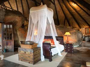  The Cecil John Rhodes Suite is the most secluded lodge, elevated to the back of the main area and behind Suite 8. There are 36 steps up to the room so would be most suitable for those guests that don’t mind a little uneven terrain.  The suite consists of an ensuite bathroom with toilet, his & hers showers, outside bath, rock basin, tea & coffee stations, a lounge area, fan, mosquito net, mosquito coils, open wardrobe, king-size bed, hairdryers & electric blankets. This suite boasts a swing bridge leading out to a private viewing sala overlooking the waterhole.