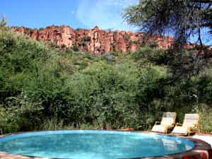 After pitching tent, guests can cool down in the shaded pool and enjoy the view to the sandstone cliffs of the Waterberg.