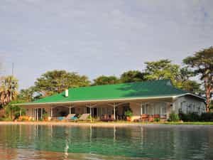 The shady verandah with outdoor seating and dining area overlooks the pool and the Zambezi