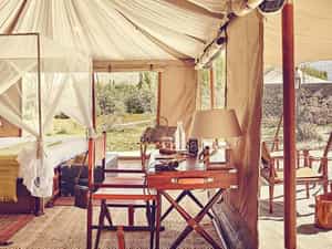 Private patio attached to each tent, furnished with hand-picked contemporary items with a nomadic theme, Intricately designed wooden chandeliers, Modern amenities like air-conditioners and heaters, Comfortable memory foam mattress that moulds perfectly to give you a good night’s sleep, The most luxurious fabrics, and a great selection of soft duvets and pillows, A writing desk, with custom stationery, A mini-bar and a complimentary welcome hamper, En-suite bathroom, A large cupboard, with an electronic safe, Shower cubicle with round-the-clock hot and cold water, Hair dryer and shaver socket, Custom-made bedroom slippers, eye masks and earplugs
