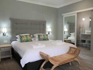Spacious Deluxe Double Chalet featuring king-size bed, en-suite bathroom, air-conditioning, refreshment station, private veranda and private deck with views of the Chobe River.