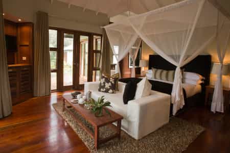 "The sleeping room is framed in glass doorways that lead to un outdoor deck."