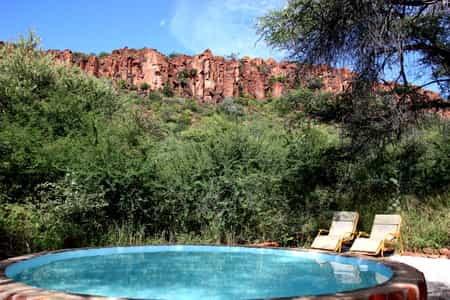 After pitching tent, guests can cool down in the shaded pool and enjoy the view to the sandstone cliffs of the Waterberg.
