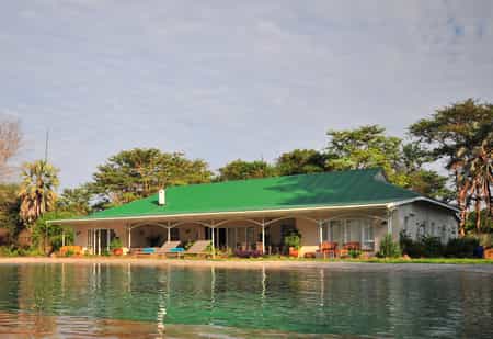 The shady verandah with outdoor seating and dining area overlooks the pool and the Zambezi