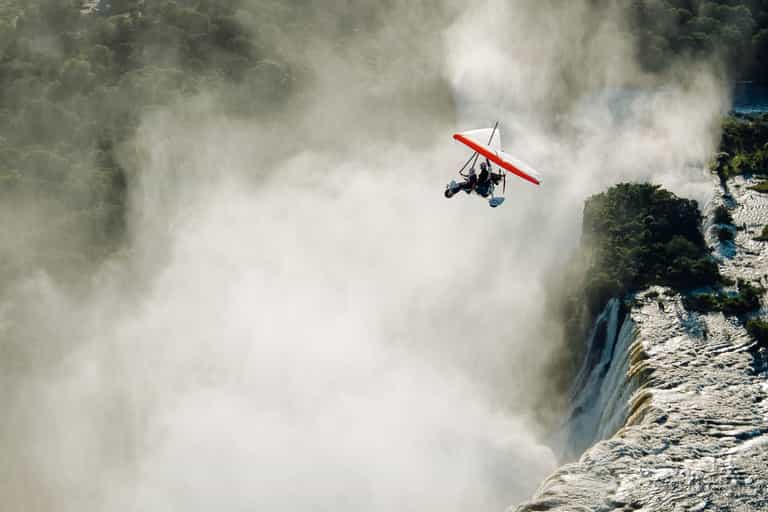 Glide above the Falls in an open-air microlight.